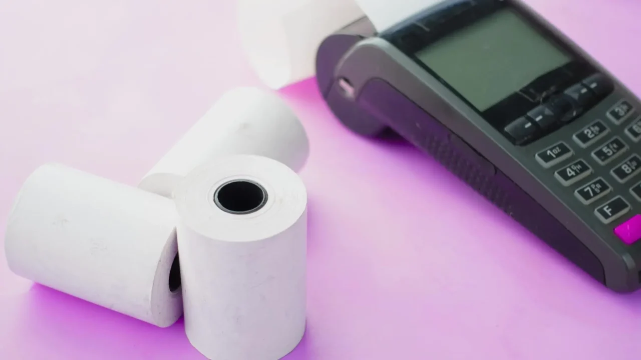 About us | Card payment machine with thermal till rolls on a purple background, representing GSP Industries as South African thermal paper specialists.